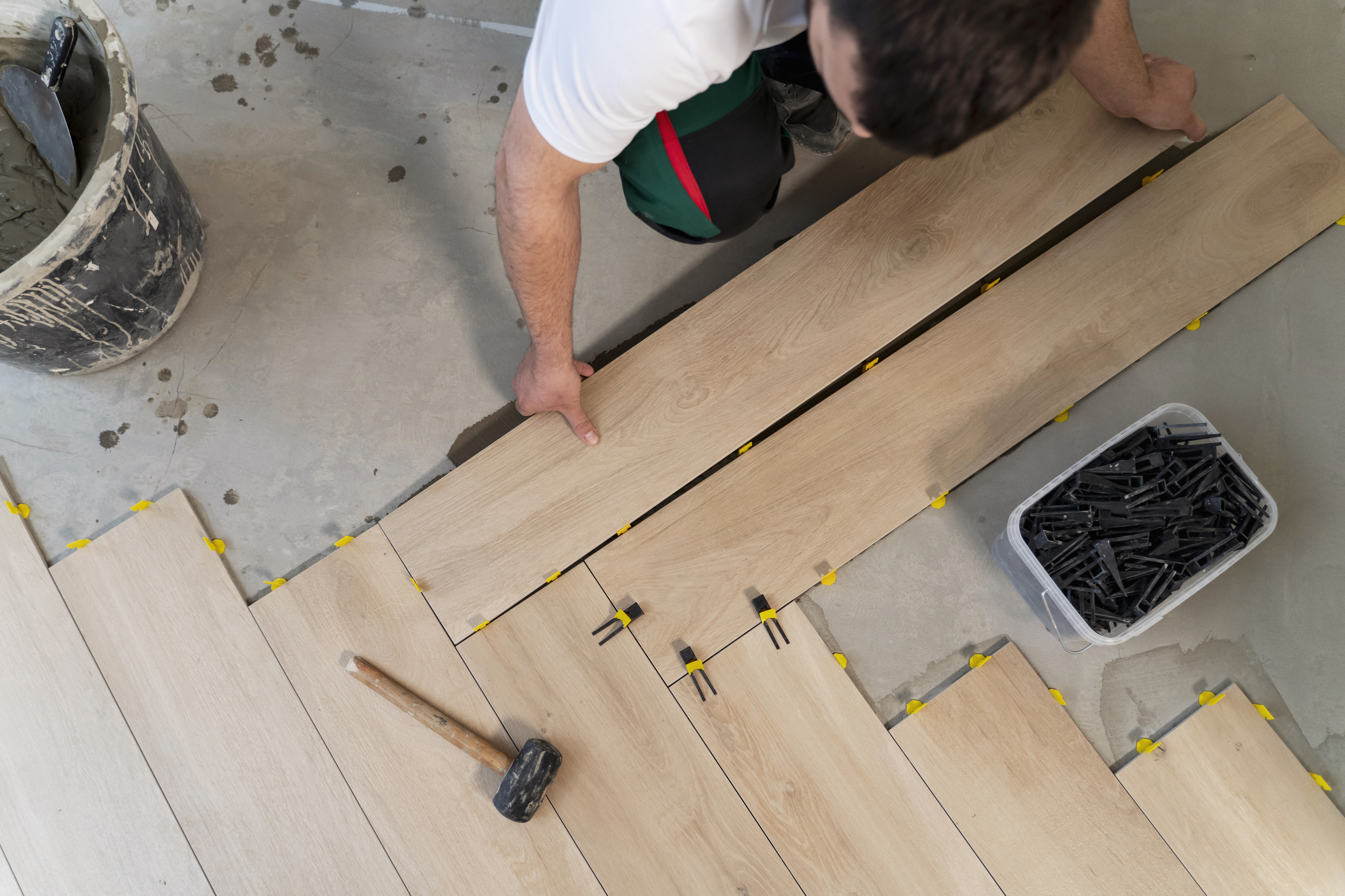 Une photo d'un artisan qui pose du parquet flottant